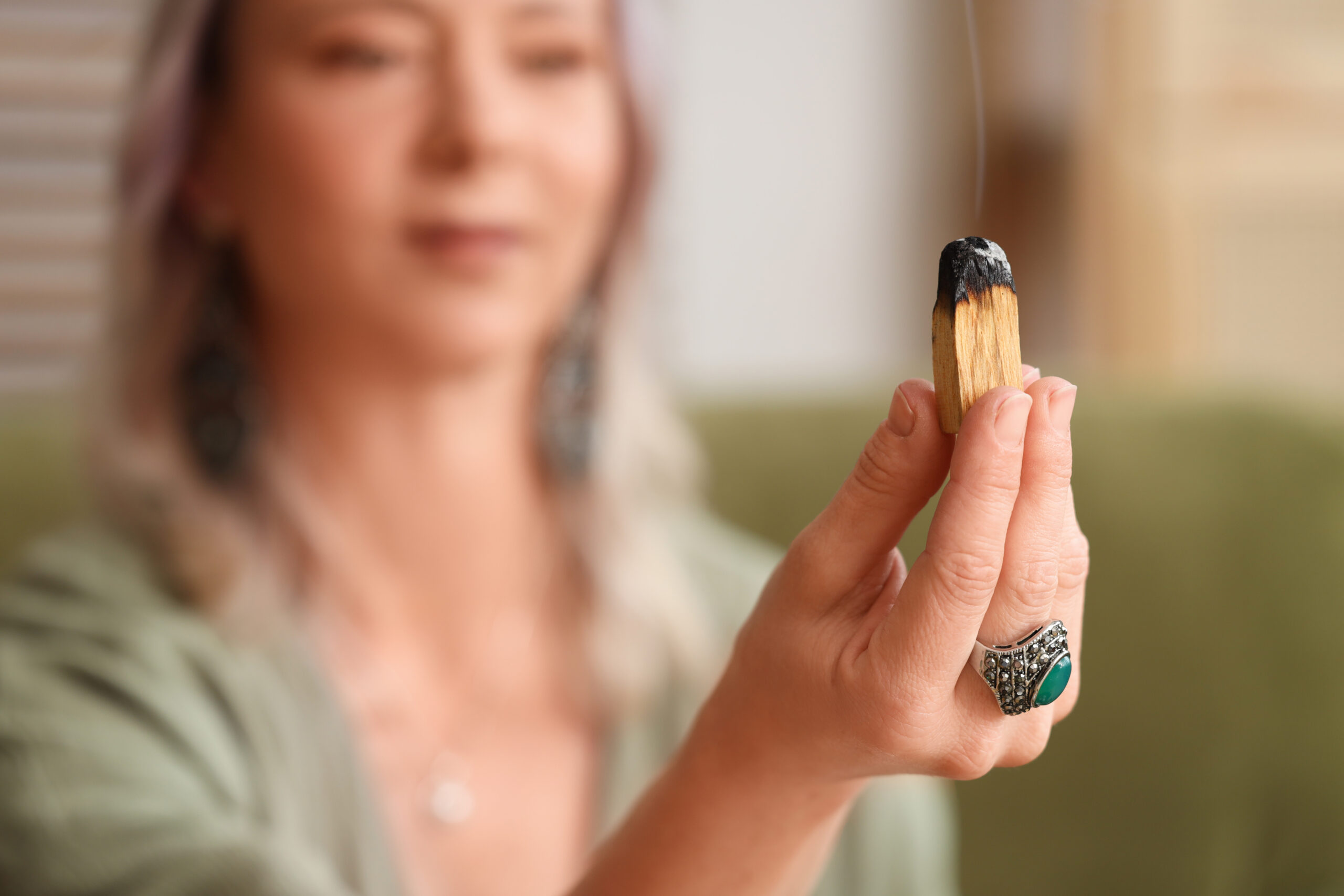 Woman with burning Palo Santo at home, closeup